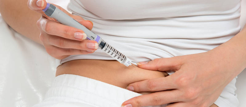 woman using insulin shot